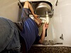 man repairing sink drain on the kitchen