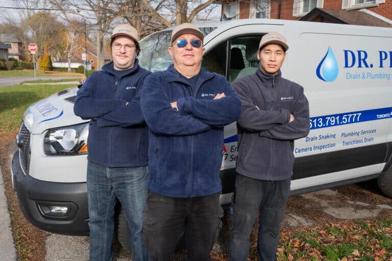 Three Dr. Pipe technicians standing in front of a service van arriving for a pipe bursting service in Ottawa