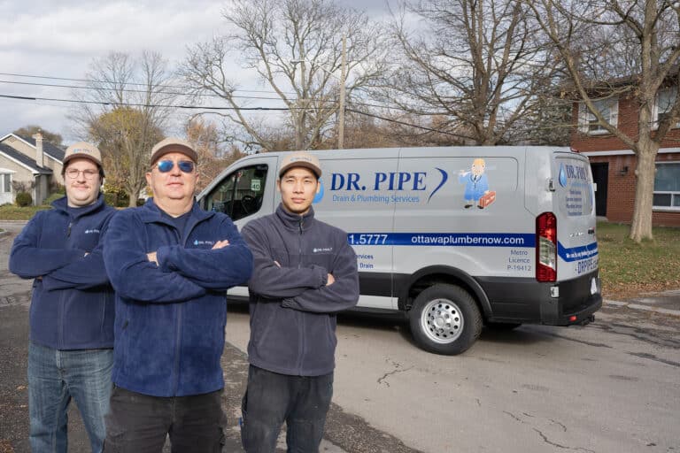 Three Dr. Pipe technicians standing in front of a service van in Ottawa